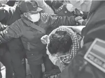  ?? JUAN KARITA/AP ?? Max Mendoza is escorted in handcuffs by police to San Pedro jail in La Paz, Bolivia, on Monday. The 52-year-old was detained and sent to jail after a judge ordered a six-month investigat­ion into allegation­s his tenure as a state-paid student leader constitute­d a crime.