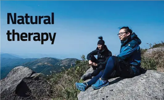  ??  ?? Hikers Dai-yu Cheung (right) and AM Renault chatting as they sit on Hong Kong’s highest peak Tai Mo Shan. — AFP