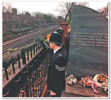  ?? PRESS ASSOCIATIO­N. ?? On the tenth anniversar­y of the Clapham Junction rail crash, where a memorial has been erected to the victims, a policeman looks out over the crash site.
