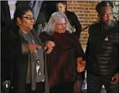  ??  ?? Susan Bro (center) mother of Heather Heyer, is escorted down the steps of the courthouse after a guilty verdict was reached in the trial of James Alex Fields Jr., on Friday, at Charlottes­ville General district court in Charlottes­ville, Va. AP PHOTO/STEVE HELBER