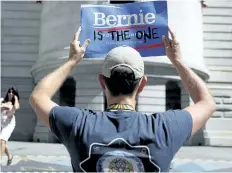  ?? JOHN MINCHILLO/ASSOCIATED PRESS ?? A supporter of Sen. Bernie Sanders holds up a sign in Philadelph­ia on Tuesday, during the second day of the Democratic National Convention.