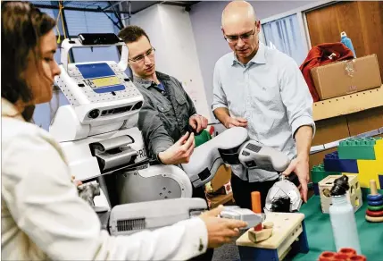  ?? PETER EARL MCCOLLOUGH / THE NEW YORK TIMES 2015 ?? Pieter Abbeel (right), a professor at the University of California, Berkeley, works on a robot in a campus research lab with doctoral student Chelsea Finn (left) and post-doctoral researcher Sergey Levin. With human experts in short supply, computer...