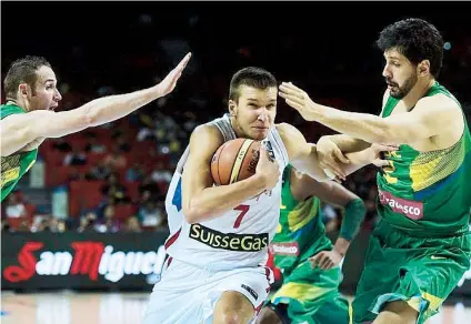  ??  ?? Bogdan Bogdanovic, de Serbia, se le escapa a los brasileños Marcelinho Huertas y Guilherme Giovannoni en el duelo de cuartos de final.