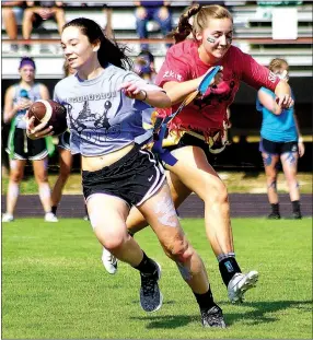  ?? Westside Eagle Observer/RANDY MOLL ?? Ahrya Reding, a junior, carries the ball while senior Jaydon Jarnagan pulls her flags during the powderpuff football game at Gentry High School on Oct. 3. For story and more photos, see Page A7.