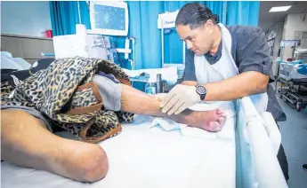  ?? Photo / Jason Oxenham ?? Podiatrist Lawrence Kingi attends to a patient at Middlemore Hospital.