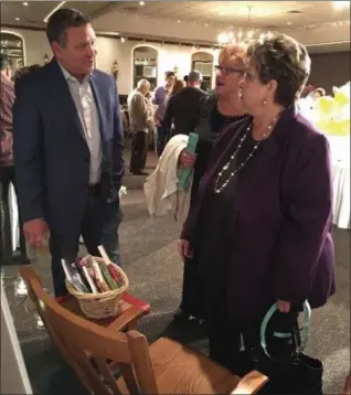  ?? RICHARD PAYERCHIN — THE MORNING JOURNAL ?? Tom Godlewski, left, speaks with Beth Finnegan, director of the Mercy Health Resource Mothers Program, right, as her sister-in-law, Mary Ann Finnegan, looks on during the first Rock N’ Read fundraiser in memory of Lorain teacher Anne Godlewski. The...