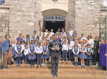  ?? Adam Carey ?? Father Paul Porter stands with St. Mary’s Catholic School students Thursday as the church receives its historic designatio­n plaque from the city of Rome.