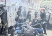  ?? REUTERS ?? KFOR soldiers clash with Kosovo Serb protesters at the entrance of the municipali­ty office, in the town of Zvecan on Monday.