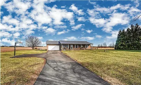  ?? CONTRIBUTE­D PHOTOS ?? The front of the custom-built ranch home has a long, newly paved driveway, basketball hoop, full wood front porch and attached, two-car garage.