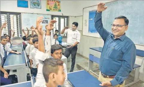  ?? SANCHIT KHANNA/HT PHOTO ?? Principal CS Verma (blue shirt) and teacher Suresh Kumar during a happiness class at Kautilya Government Sarvodaya Bal Vidyalaya.