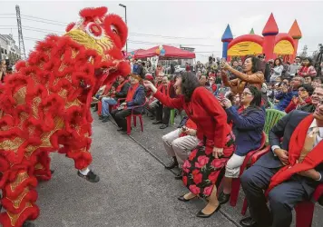  ?? Photos by Steve Gonzales / Staff photograph­er ?? Alice Chen, a candidate for Stafford City Council, gives the dragon a hóngbao, or red envelope, for luck at the Lunar New Year Festival. Candidates and activists used the event to campaign and register voters.
