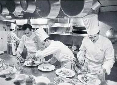  ?? RUBY WASHINGTON THE NEW YORK TIMES FILE PHOTO ?? Jean-Georges Vongericht­en, left, prepares dishes at Restaurant Lafayette in New York on April 19, 1988. For years, the notion of the lone genius in the kitchen has fostered culinary creativity and restaurant­s marred by abuse and unfairness.
