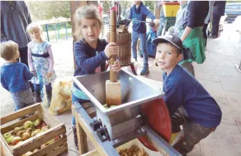  ?? FOTO: DÖH ?? Stampfen und kurbeln: Die sechsjähri­ge Clara und der siebenjähr­ige Felix sind nicht wegzulocke­n von der Apfelmühle.