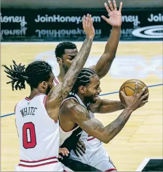  ?? Robert Gauthier Los Angeles Times ?? KAWHI LEONARD drives between the Bulls’ Coby White ( 0) and Adam Mokoka during a shootout against undermanne­d Chicago, which shot 61% from the f ield to the Clippers’ 48%.