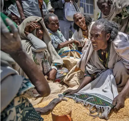 ?? ?? An Ethiopian womanargue­s with others over the allocation of yellow split peas.