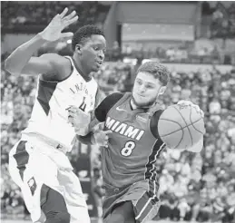  ?? MICHAEL CONROY/AP ?? Heat guard Tyler Johnson (8) drives on Indiana Pacers guard Victor Oladipo early in Sunday’s game, won by the Pacers with a strong overtime.