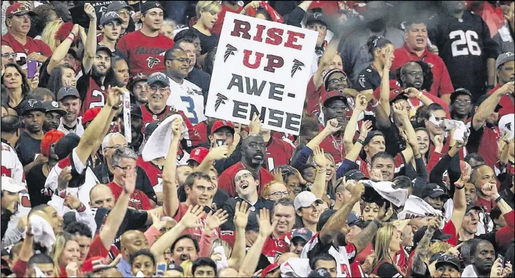  ?? CURTIS COMPTON/CCOMPTON@AJC.COM ?? Falcons fans show their spirit as the Atlanta took a 36-13 lead over the Seahawks during the fourth quarter of Saturday’s game.