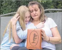  ?? CP PHOTO ?? Denise Lane and her daughter Megan sit with the urn containing the ashes of her son Shawn Kelly Jr. in Innisfil, Ont., on Friday. Lane searches her mind for fond memories of her son, who died of a fentanyl overdose.