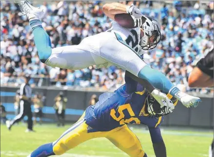  ?? Photograph­s by Wally Skalij Los Angeles Times ?? CHRISTIAN McCAFFREY of Carolina goes airborne as Cory Littleton makes one of his game-high 14 tackles. The Rams’ Pro Bowl linebacker also broke up two passes, had an intercepti­on, forced a fumble and recovered one, but still said, “We can be a lot better.”