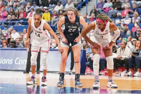  ?? M. Anthony Nesmith/Icon Sportswire via Getty Images ?? UConn’s Aubrey Griffin, left, and Aaliyah Edwards flank Villanova’s Maddy Siegrist during a foul shot at the XL Center in Hartford on Jan. 29.