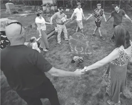  ?? PHOTOS: CHARLES KRUPA/THE ASSOCIATED PRESS ?? Relatives of Walter Skold, founder of the Dead Poets Society of America, dance around his grave.