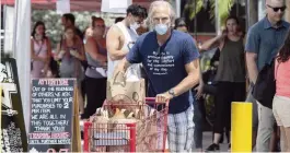  ?? AL DIAZ adiaz@miamiheral­d.com ?? Grocery shoppers gather at Trader Joe’s at 9205 South Dixie Highway in Miami on Tuesday. A new Miami-Dade order requires grocery stores to limit capacity by 50%.