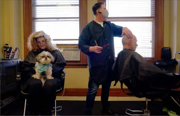  ?? Steve Mellon/Post-Gazette ?? Client Martha Yannessa, holds shih tzu Joey while Bobbie Best trims Jack Tomayko’s hair on March 13, Mr. Best’s last day at his salon in the Diamond Building in Downtown. Mr. Best is moving his business, Bobby Best Design, to the suburbs.