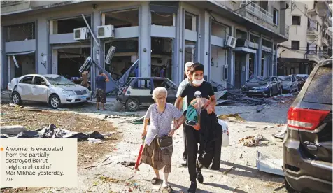  ?? AFP ?? A woman is evacuated from the partially destroyed Beirut neighbourh­ood of Mar Mikhael yesterday.