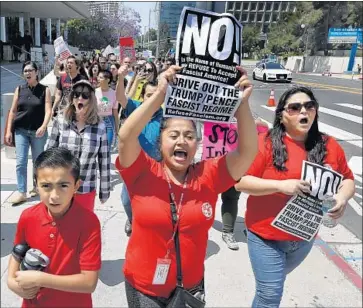  ?? Mel Melcon Los Angeles Times ?? KARLA PARRA of Pomona, center, and her son Donoven, 10, rally Thursday outside the Roybal Federal Building in downtown Los Angeles to protest the Trump administra­tion’s separation of immigrant families.