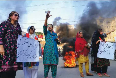  ?? AP ?? Supporters of former Prime Minister Imran Khan’s party block a road in Hyderabad during a protest against the election commission’s decision to disqualify their leader.