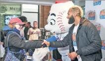  ?? Robert Sabo ?? GIVING BACK: Christine Goodwin of Rockville Centre, L.I., shakes hands with Amed Rosario during the Mets’ annual food drive Tuesday at Citi Field.