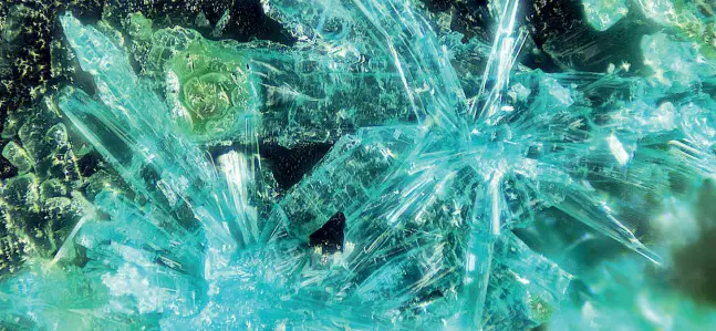  ??  ?? Fiammeite Ecco il minerale scoperto dai ricercator­i del Muse in un’immagine al microscopi­o in cui spicca il color turchese acceso dei cristalli