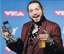  ?? EVAN AGOSTINI/THE ASSOCIATED PRESS ?? Post Malone poses with the award for song of the year for Rockstar in the press room at the MTV Video Music Awards in New York on Monday, the day before his eventful flight.