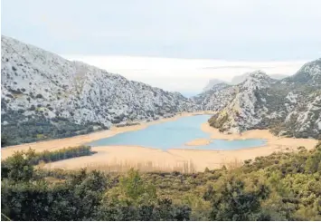  ?? Foto: Stephanie Schuster, dpa ?? Die Wasserrese­rven auf Mallorca gehen zur Neige. Weil es im Winter so wenig geregnet hat, sind Stauseen, wie hier der Gorg Blau, so gut wie leer. Das hat Folgen für die Inselbewoh­ner und könnte nun auch Urlauber treffen.