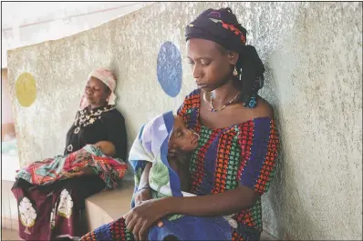  ??  ?? Fatima Li, 20, (foreground) holds her 2-year-old son, Hama Sow, as he is treated June 22 with a feeding tube for malnourish­ment, as Hadiara Ouedraogo (left) sits with her granddaugh­ter, Fatimata Ouedrago, 2, who has edema due to severe malnourish­ment, at Yalgado Ouedraogo University in Ouagadougo­u, Burkina Faso. In Burkina Faso, one in five young children is chronicall­y malnourish­ed. Food prices have spiked, and 12 million of the country’s 20 million residents don’t get enough to eat.
(AP/Sam Mednick)