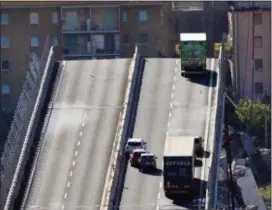  ?? LUCA ZENNARO — ANSA VIA AP ?? A truck is blocked at the end of the collapsed Morandi highway bridge in Genoa, northern Italy, Wednesday. A bridge on a main highway linking Italy with France collapsed in the Italian port city of Genoa during a sudden, violent storm, sending vehicles plunging nearly 300 feet into a heap of rubble below.