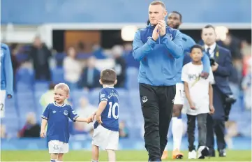  ??  ?? In this file photo taken on May 5, Wayne Rooney and his children make a walkabout on the field after the English Premier League match between Everton and Southampto­n at Goodison Park in Liverpool, north west England. — AFP photo