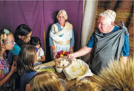  ?? STAFF PHOTO BY DOUG STRICKLAND ?? James LaMance, right, and Helen LaMance pass out food as they explain its significan­ce to Passover at a “Road to Resurrecti­on” event held at Red Bank Cumberland Presbyteri­an Church last Saturday. The Easter event took visitors through live scenes where...