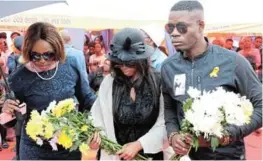  ?? ?? Bokgabo Poo’s parents, Tsholofelo Poo and Irvin Ndlovu, holding flowers during their daughter’s burial.