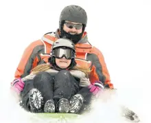  ?? CLIFFORD SKARSTEDT/EXAMINER ?? Downhill thrills on a fresh bed of snow for Tavin Yurick, 10, and dad Mike during cold -12C weather on Tuesday on Armour Hill. Temperatur­es are expected to remains very cold in the days ahead.