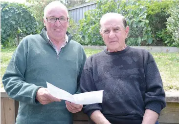  ??  ?? Baw Baw Livestock Exchange manager John Cochrane goes through the sales details of a bullock Nick Dilauro (right) sold at the Warragul Saleyards. Nick is donating the funds to Ambulance Victoria, West Gippsland Hospital and Monash Heart Foundation.