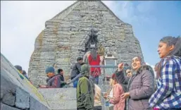  ?? PTI ?? Security personnel stand guard as devotees wait in a queue to offer prayers at Shankarach­arya temple on the occasion of Mahashivra­tri in Srinagar on Friday.