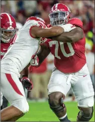  ?? (AP file photo) ?? Alabama offensive tackle Alex Leatherwoo­d (right) blocks Arkansas defensive end Mataio Soli last season. Leatherwoo­d won the Outland Trophy this season for the nation’s top interior lineman.