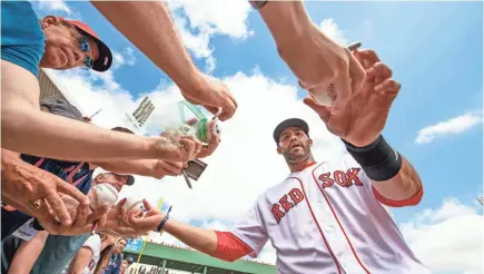  ?? DOUGLAS DEFELICE/USA TODAY SPORTS ?? Outfielder J.D. Martinez signs autographs for Red Sox fans shortly after the free agent signed a five-year, $110 million contract in late February.