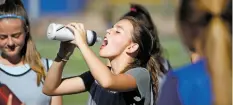  ??  ?? Santa Fe High School soccer player Bella Merchant, 15, stays hydrated during practice Tuesday.