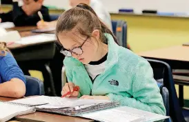  ??  ?? Mackenzie Stephens, a fifth-grade student at Deer Creek Intermedia­te School, works on her math assignment.