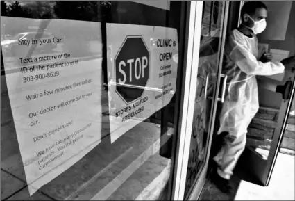  ?? AP Photo/Thomas Peipert ?? In this April 22 file photo, Dr. P.J. Parmar heads to the parking lot of his clinic in Aurora, Colo., to see a patient.