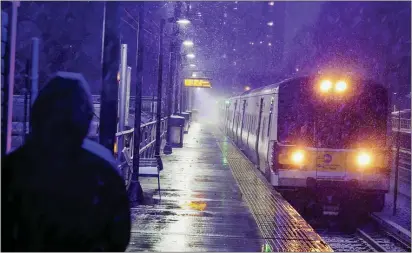  ?? FRANK FRANKLIN II — THE ASSOCIATED PRESS ?? A woman waits for a Long Island Rail Road train in the Queens borough of New York as snow falls at the start of an oncoming snow storm, Wednesday, Dec. 16, 2020.