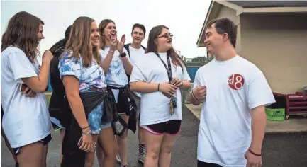  ??  ?? Ben Halvorson, 18, converses with fellow seniors about their college plans during Senior Day at Bartlett High School on Friday. Halvorson will be the first student in Bartlett City Schools to have Down Syndrome and graduate with a general education...