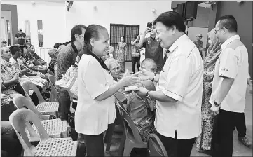  ??  ?? Mawan (right) hands over a BR1M voucher to a recipient.